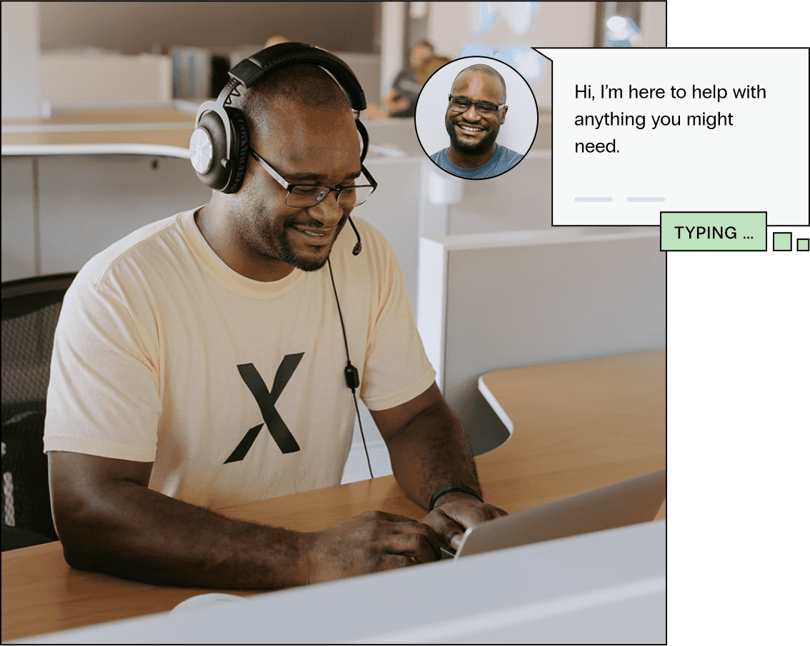 Support team member smiles looking at his computer, he types Hi I’m here to help with anything you might need in a chat