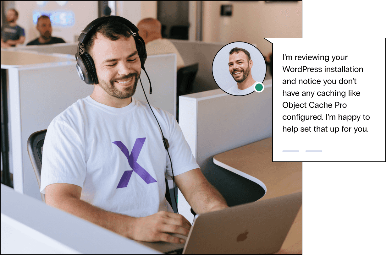 Young man in a Nexcess shirt and acoustic headphones smiles as he talks to a customer, he says let’s start by getting your system information.