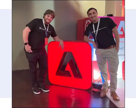 Improntus staff posing with the Adobe logo.